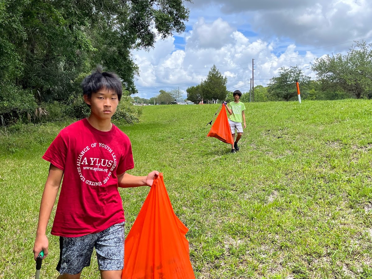 Image of Jason Wang digging a hole to plant the precious friut trees.